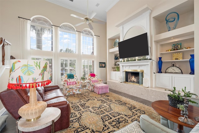 226 Northline Rd, Teague, TX 75860 - living room with built in shelves, a towering ceiling, crown molding, a high end fireplace, and a ceiling fan