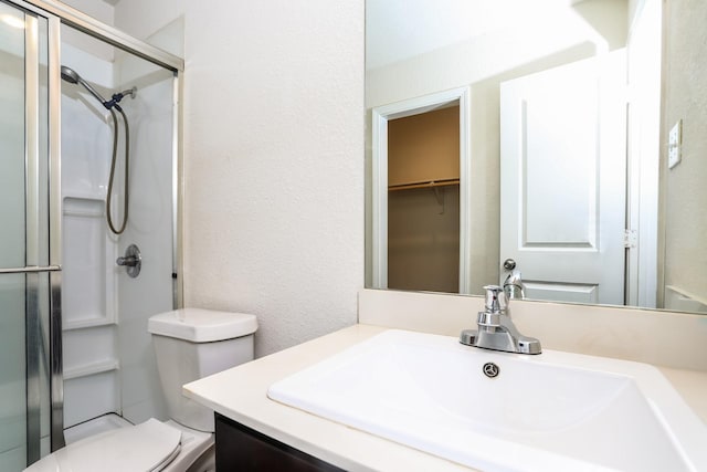 2515 Lyle Ave, Waco, TX 76708 - bathroom with a shower stall, toilet, vanity, a textured wall, and a spacious closet
