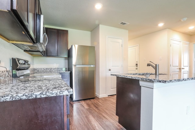 2515 Lyle Ave, Waco, TX 76708 - kitchen with freestanding refrigerator, electric range, wood finished floors, a sink, and light stone countertops