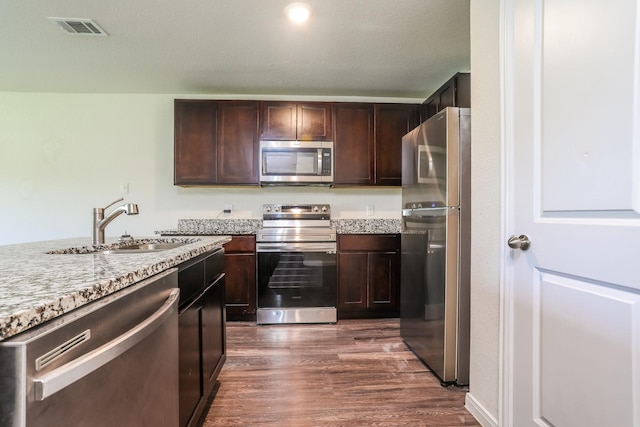 2515 Lyle Ave, Waco, TX 76708 - kitchen with stainless steel appliances, a sink, dark wood-style flooring, and dark brown cabinetry