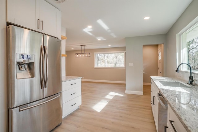 890 Nash Ln, Lipan, TX 76462 - kitchen featuring appliances with stainless steel finishes, a sink, baseboards, light wood-style floors, and white cabinetry