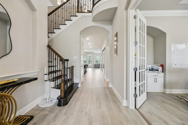 4871 Lockwood Dr, Prosper, TX 75078 - entryway featuring arched walkways, wood finished floors, stairs, ornamental molding, and french doors