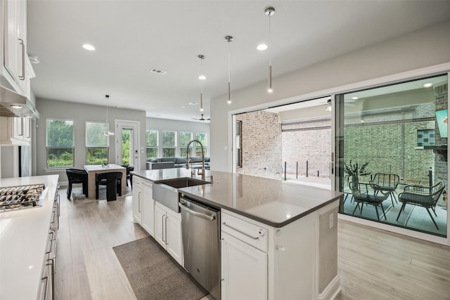 4871 Lockwood Dr, Prosper, TX 75078 - kitchen with appliances with stainless steel finishes, light wood-type flooring, white cabinets, a center island with sink, and recessed lighting
