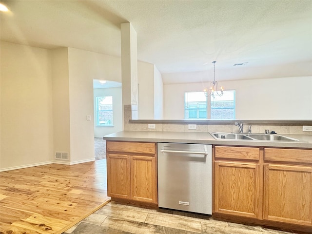 116 Bison Meadow Dr, Waxahachie, TX 75165 - kitchen with stainless steel dishwasher, a sink, a chandelier, light wood finished floors, and light countertops