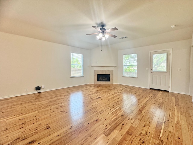 116 Bison Meadow Dr, Waxahachie, TX 75165 - unfurnished living room with light wood-type flooring, a ceiling fan, plenty of natural light, and a tile fireplace