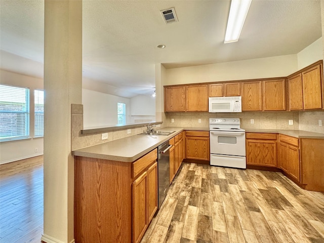 116 Bison Meadow Dr, Waxahachie, TX 75165 - kitchen with white appliances, light wood-type flooring, a sink, tasteful backsplash, and brown cabinets