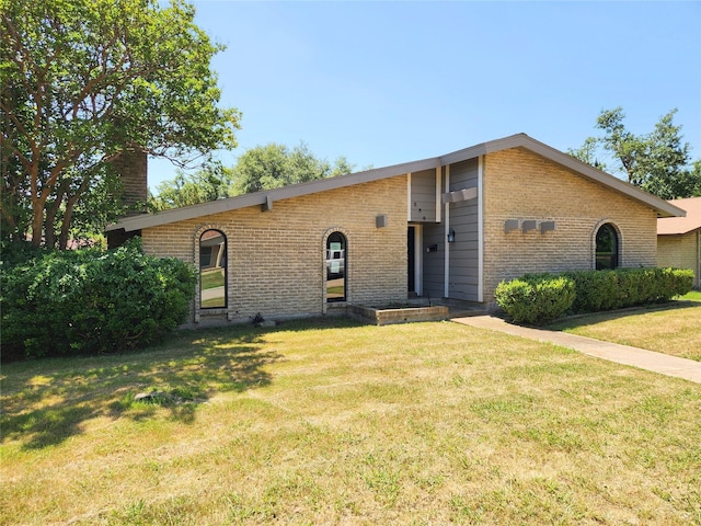 338 Wildbriar Dr, Garland, TX 75043 - view of front facade featuring brick siding, a chimney, and a front lawn