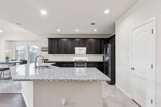 824 Water Garden Cir, Little Elm, TX 75068 - kitchen with stainless steel appliances, a spacious island, recessed lighting, light stone countertops, and under cabinet range hood