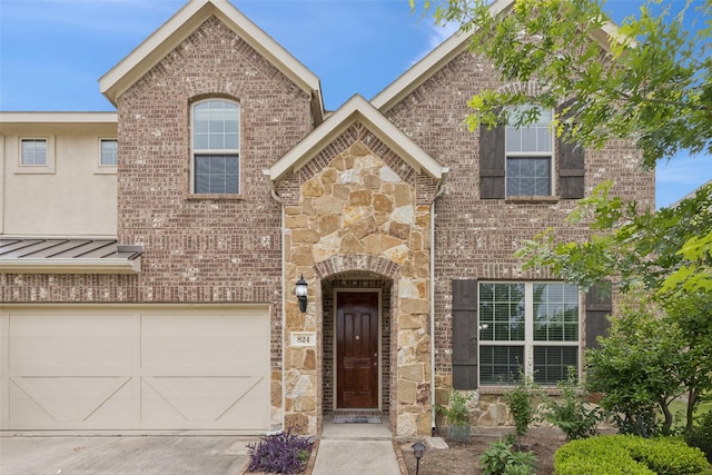 824 Water Garden Cir, Little Elm, TX 75068 - view of front of house featuring stone siding, driveway, an attached garage, brick siding, and a standing seam roof