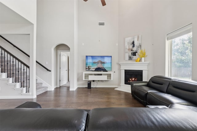 824 Water Garden Cir, Little Elm, TX 75068 - living room with a high ceiling, wood finished floors, ceiling fan, stairway, and a lit fireplace