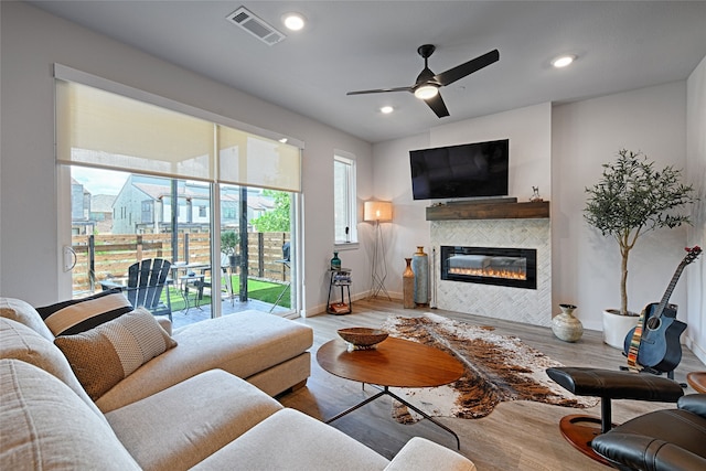 841 Emerling Dr, Mckinney, TX 75069 - living room with wood finished floors, a tiled fireplace, a ceiling fan, baseboards, and recessed lighting