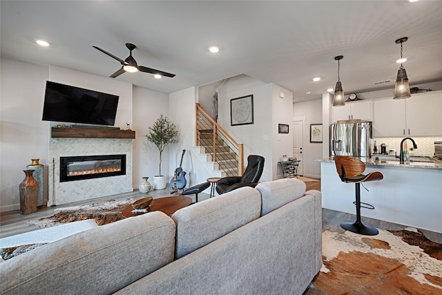 841 Emerling Dr, Mckinney, TX 75069 - living area with dark wood finished floors, stairs, a glass covered fireplace, ceiling fan, and recessed lighting