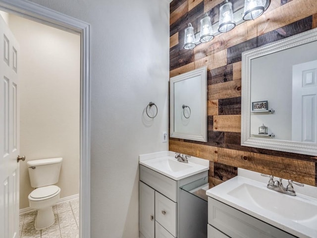 1676 Castle Pines Dr, Frisco, TX 75036 - full bath with two vanities, toilet, wooden walls, and tile patterned floors