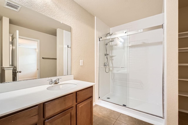 1112 Roman Dr, Princeton, TX 75407 - bathroom with a shower stall, vanity, tile patterned flooring, a textured wall, and a spacious closet