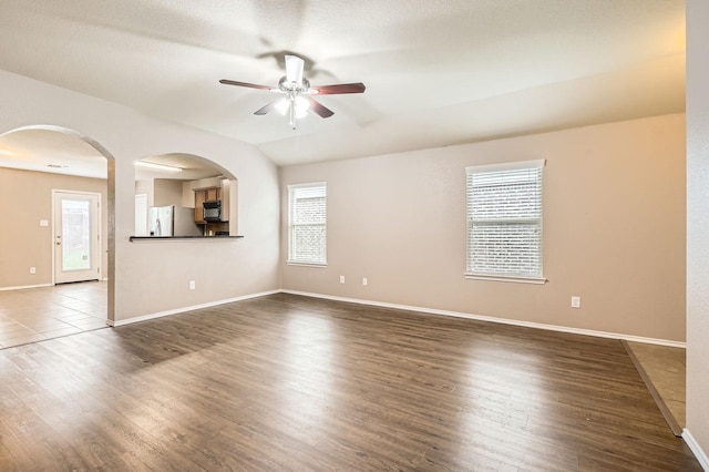 1112 Roman Dr, Princeton, TX 75407 - unfurnished living room with ceiling fan, healthy amount of natural light, wood finished floors, baseboards, and vaulted ceiling
