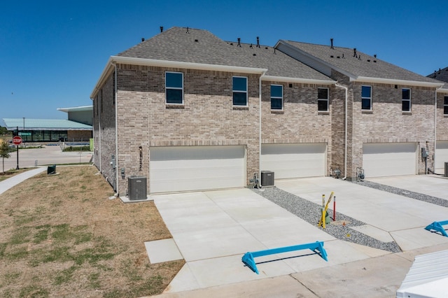 1800 Summer Aura, Mesquite, TX 75181 - view of side of property featuring an attached garage, central air condition unit, concrete driveway, and a shingled roof