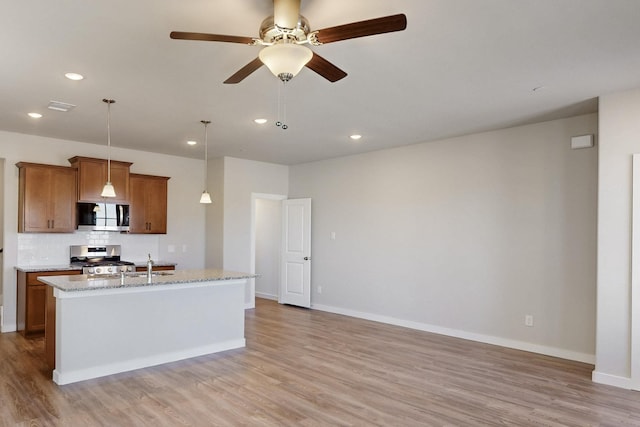 1808 Summer Aura, Mesquite, TX 75181 - kitchen with stainless steel appliances, brown cabinets, light wood finished floors, and recessed lighting