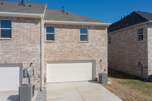 1804 Summer Aura, Mesquite, TX 75181 - rear view of house featuring an attached garage, central AC, concrete driveway, and a shingled roof