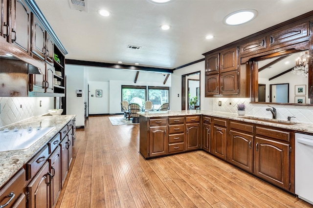 1345 Meadow Gln, Southlake, TX 76092 - kitchen with a sink, white appliances, light wood-type flooring, decorative backsplash, and a peninsula