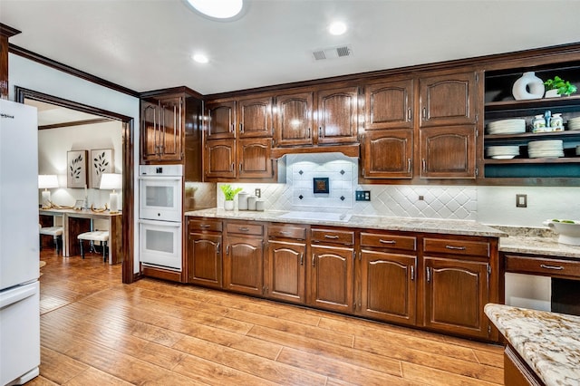 1345 Meadow Gln, Southlake, TX 76092 - kitchen with white appliances, crown molding, backsplash, light wood-style flooring, and light stone countertops