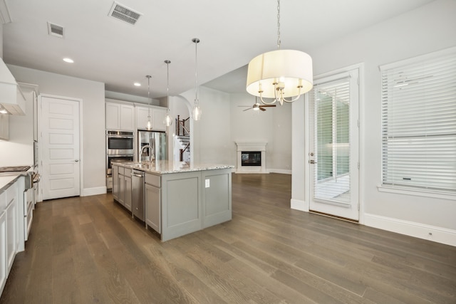 975 Stampede Dr, Frisco, TX 75036 - kitchen with a chandelier, recessed lighting, baseboards, dark wood finished floors, and appliances with stainless steel finishes