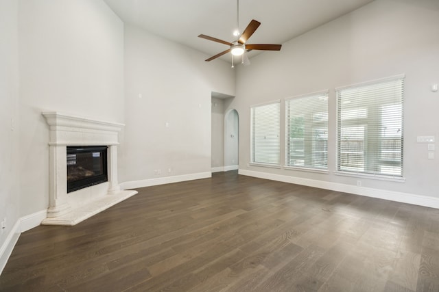 975 Stampede Dr, Frisco, TX 75036 - unfurnished living room featuring ceiling fan, arched walkways, baseboards, dark wood finished floors, and high vaulted ceiling