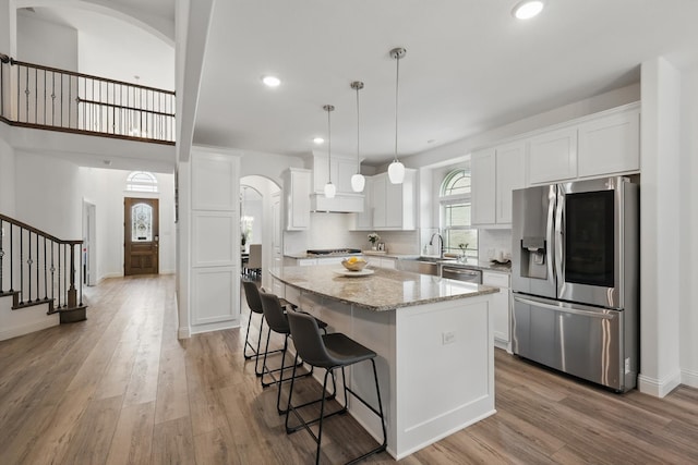 2821 White Plains Dr, Midlothian, TX 76065 - kitchen with stainless steel appliances, arched walkways, a sink, a center island, and white cabinets