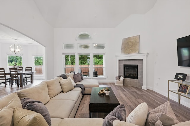 2821 White Plains Dr, Midlothian, TX 76065 - living area with high vaulted ceiling, a chandelier, a tiled fireplace, arched walkways, and wood finished floors