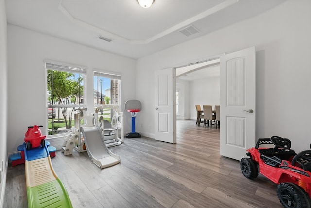 2821 White Plains Dr, Midlothian, TX 76065 - workout area featuring a tray ceiling, wood finished floors, and arched walkways
