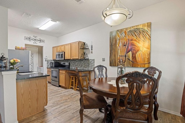 4812 Marina Del Rd, Fort Worth, TX 76179 - dining space featuring light wood-style flooring and a textured ceiling