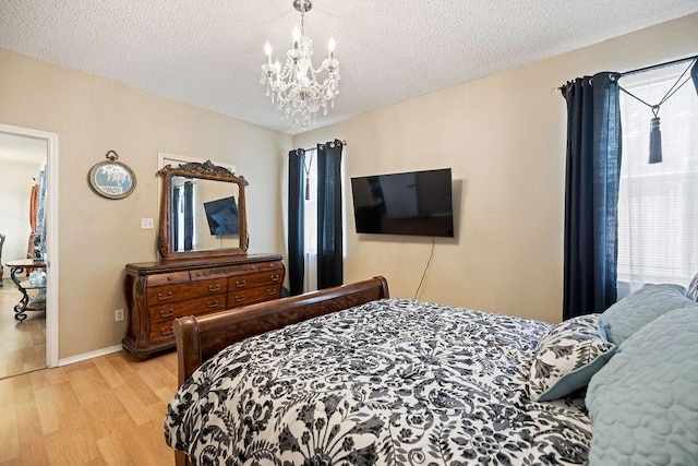4812 Marina Del Rd, Fort Worth, TX 76179 - bedroom with light wood-style flooring, a chandelier, a textured ceiling, and baseboards