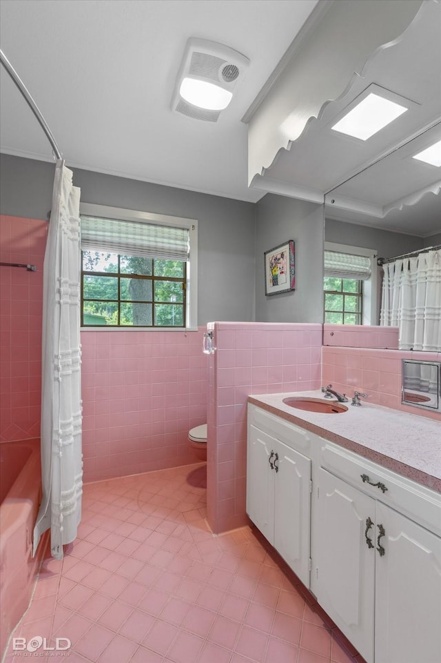 5918 Fern Ave, Shreveport, LA 71105 - bathroom featuring tile walls, vanity, toilet, healthy amount of natural light, and tile patterned flooring