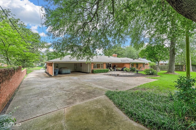 5918 Fern Ave, Shreveport, LA 71105 - rear view of property featuring concrete driveway, a chimney, and an attached carport