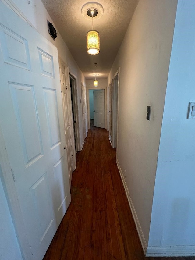 143 Brookshire Ave, Azle, TX 76020 - hall featuring dark wood-type flooring, a textured ceiling, and baseboards