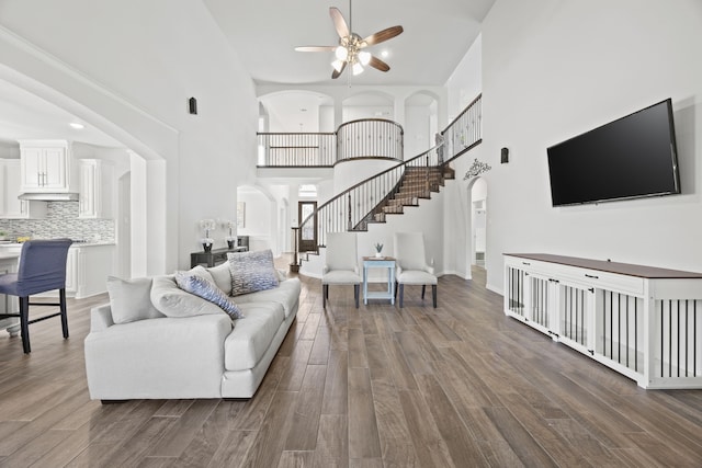 316 Cunningham Cir, Celina, TX 75009 - living area with arched walkways, stairway, a ceiling fan, a towering ceiling, and wood finished floors