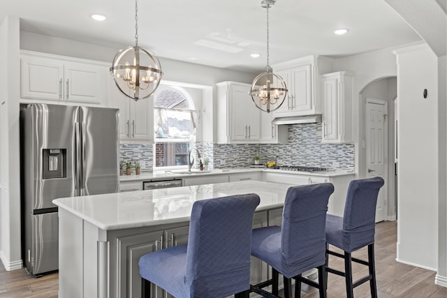 316 Cunningham Cir, Celina, TX 75009 - kitchen featuring a chandelier, appliances with stainless steel finishes, a sink, arched walkways, and recessed lighting