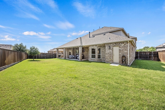 316 Cunningham Cir, Celina, TX 75009 - back of property featuring a shingled roof, brick siding, and a patio area