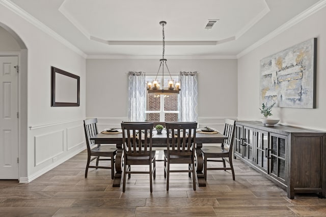 316 Cunningham Cir, Celina, TX 75009 - dining room with a chandelier, a raised ceiling, arched walkways, dark wood-style floors, and ornamental molding