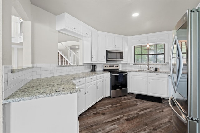 13340 Willow Springs Rd, Haslet, TX 76052 - kitchen featuring appliances with stainless steel finishes, decorative backsplash, dark wood-type flooring, white cabinetry, and recessed lighting