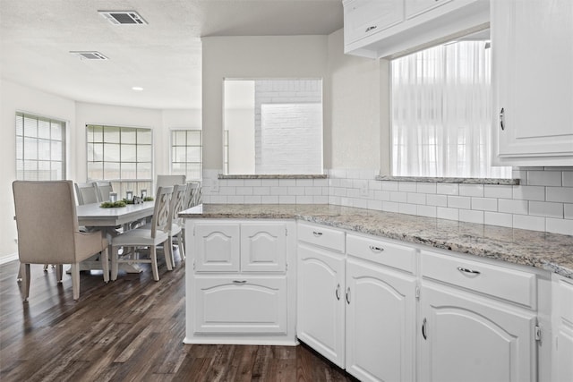 13340 Willow Springs Rd, Haslet, TX 76052 - kitchen with dark wood-style flooring, tasteful backsplash, white cabinetry, light stone counters, and a textured ceiling