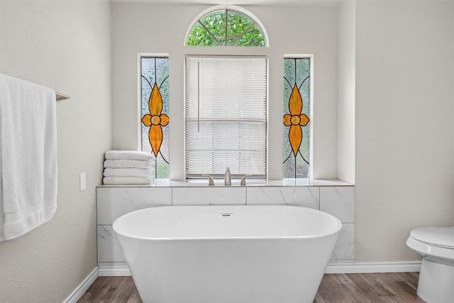 13340 Willow Springs Rd, Haslet, TX 76052 - full bathroom with wood finished floors, a freestanding bath, and baseboards