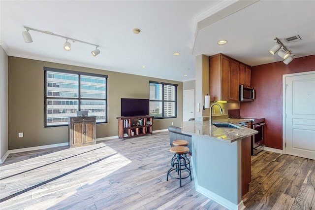 330 Las Colinas Blvd E Unit 920, Irving, TX 75039 - kitchen featuring track lighting, a sink, appliances with stainless steel finishes, light stone countertops, and ornamental molding