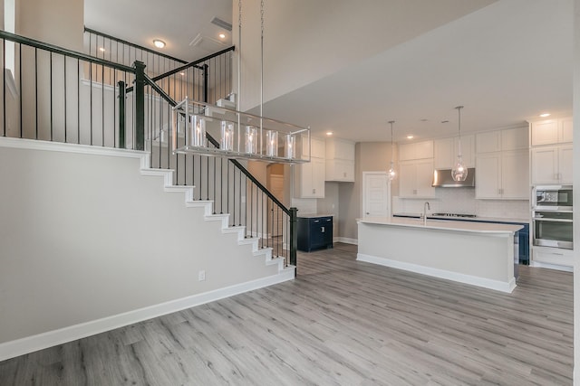 2033 Barbette St, Fort Worth, TX 76008 - kitchen featuring under cabinet range hood, appliances with stainless steel finishes, light wood-style floors, white cabinets, and light countertops