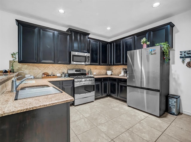 5605 Cojimar Dr, Mckinney, TX 75070 - kitchen with stainless steel appliances, dark cabinets, decorative backsplash, light tile patterned flooring, and a sink