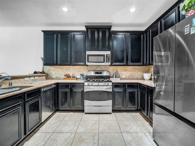 5605 Cojimar Dr, Mckinney, TX 75070 - kitchen featuring appliances with stainless steel finishes, dark cabinets, backsplash, and recessed lighting