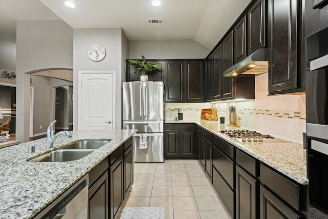 11521 Misty Mesa Dr, Fort Worth, TX 76052 - kitchen with appliances with stainless steel finishes, under cabinet range hood, a sink, tasteful backsplash, and arched walkways