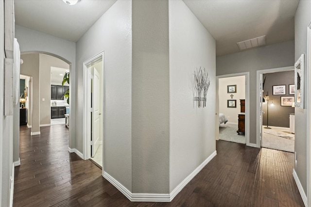 11521 Misty Mesa Dr, Fort Worth, TX 76052 - hallway featuring dark wood finished floors, arched walkways, and baseboards