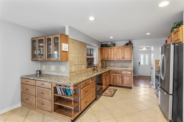 4425 Maple Shade Ave, Sachse, TX 75048 - kitchen with stainless steel appliances, light stone counters, tasteful backsplash, glass insert cabinets, and brown cabinetry