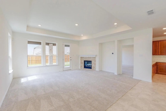 3681 Keechi Creek Dr, Celina, TX 75078 - unfurnished living room with a raised ceiling, baseboards, recessed lighting, light carpet, and a tiled fireplace