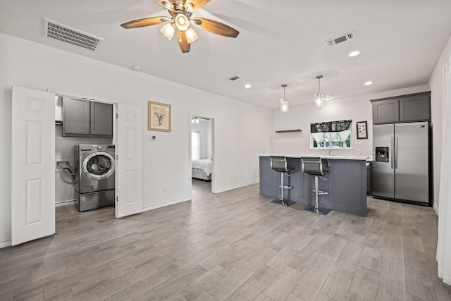 720 Aqua Vista Dr, Granbury, TX 76049 - kitchen featuring stainless steel fridge, washer / clothes dryer, light countertops, ceiling fan, and light wood-style flooring